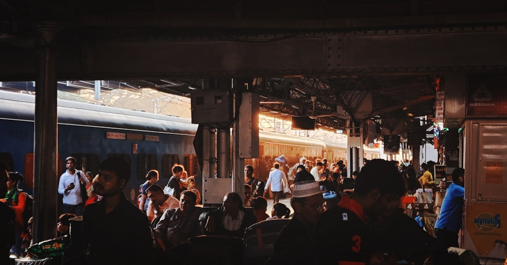 a group of people standing around a train station