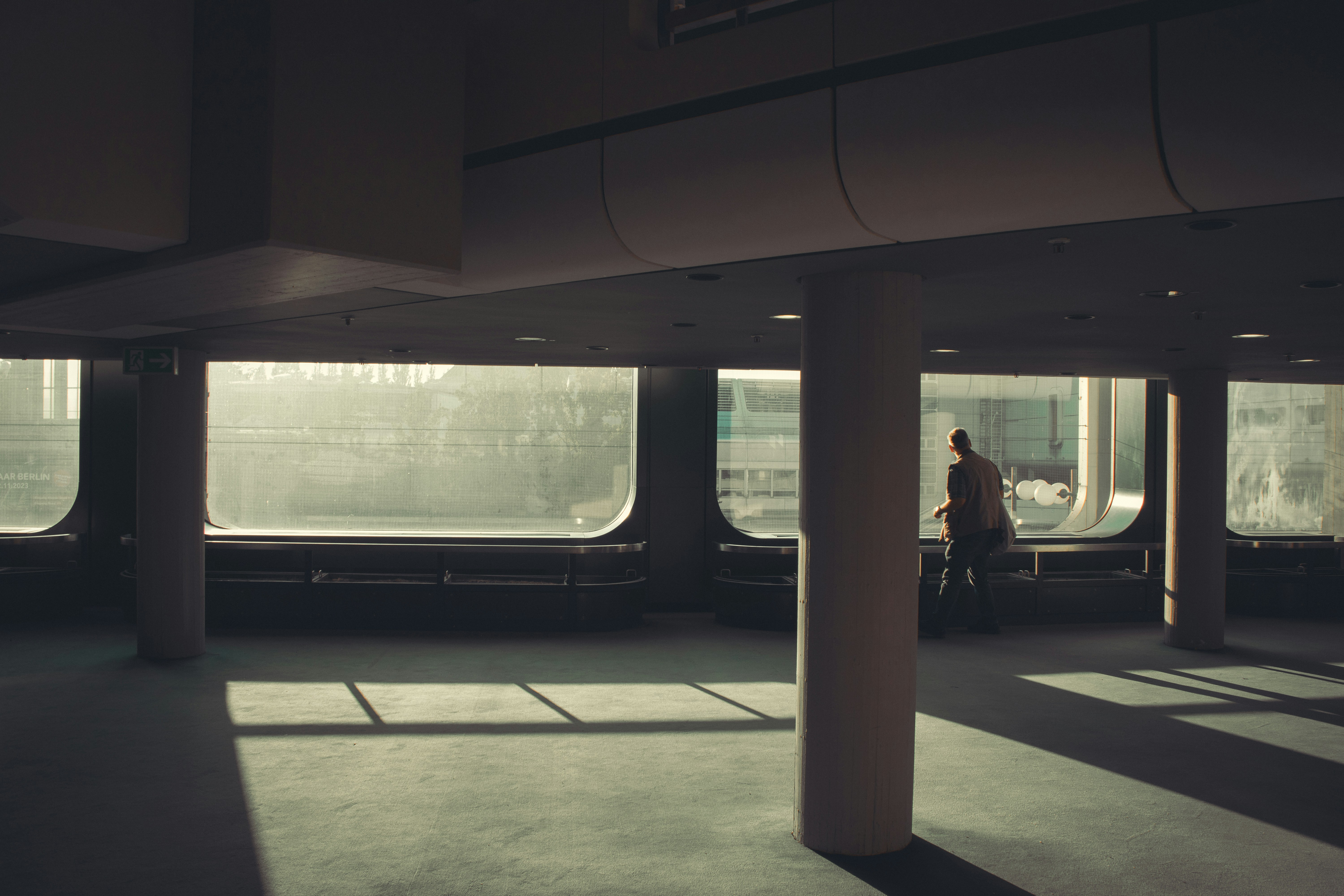 una persona in piedi in una grande stanza con molte finestre