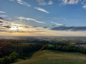 Sunset view over a peaceful countryside with rolling hills.
