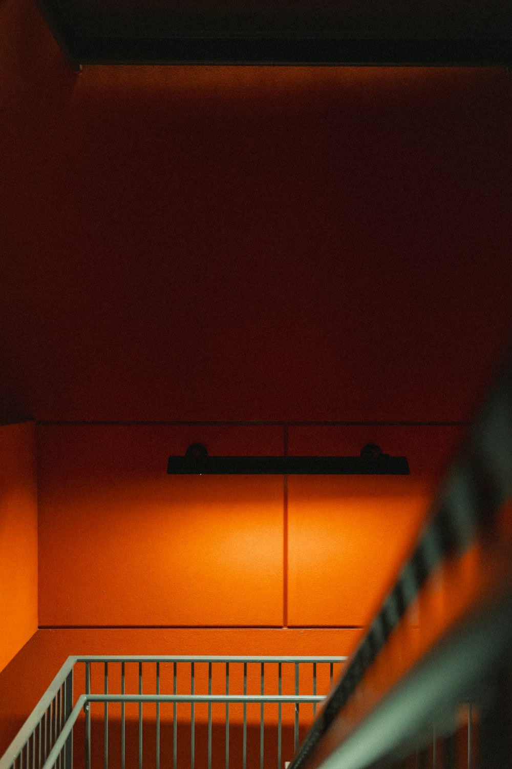 an orange room with stairs and a bench