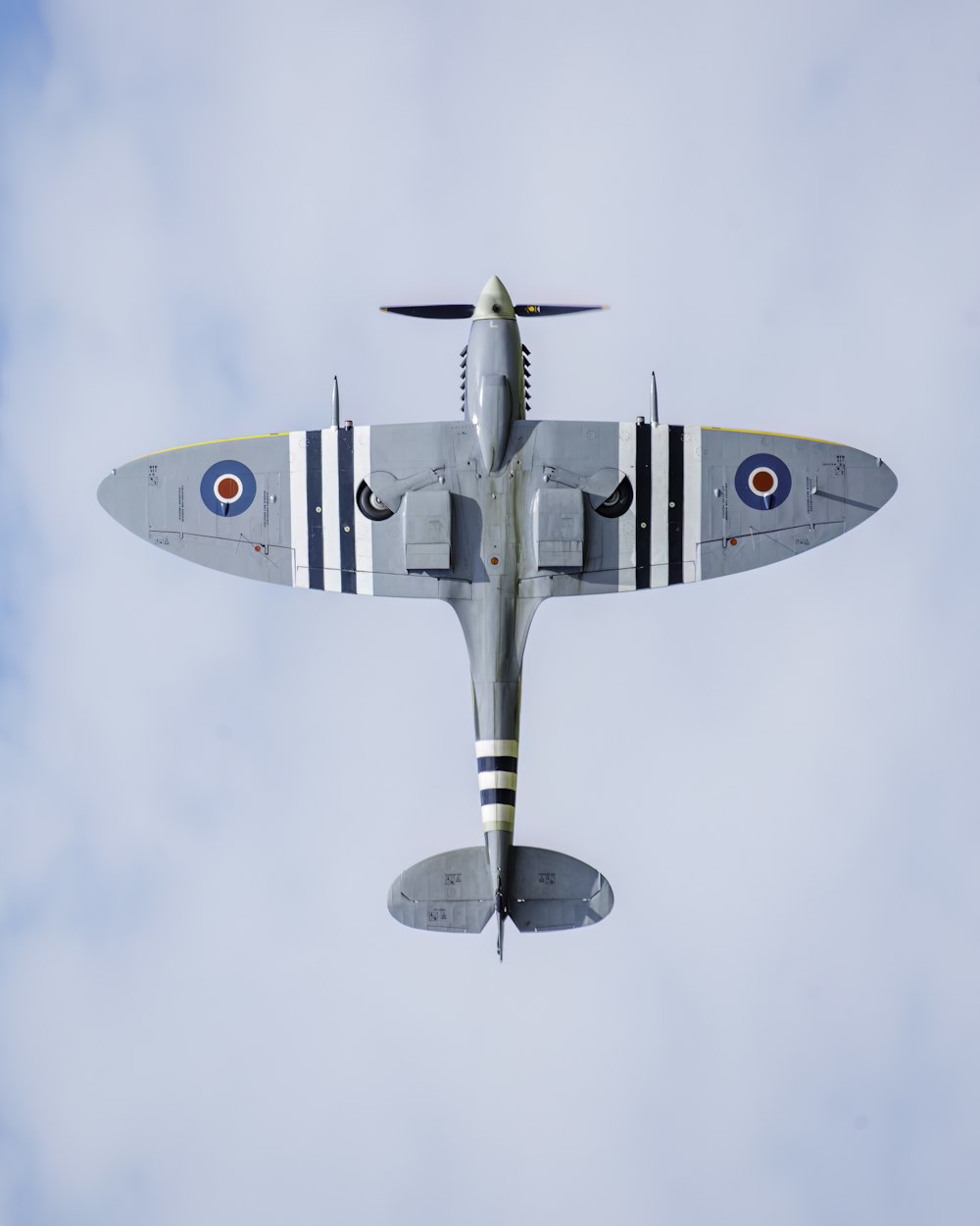 a fighter jet flying through a cloudy blue sky