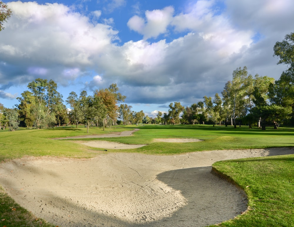 a golf course with a sand trap in the foreground
