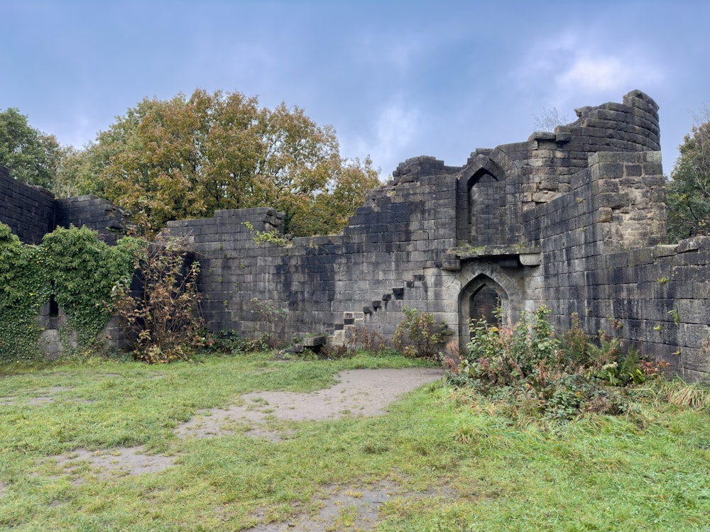 an old castle with a stone wall and stairs