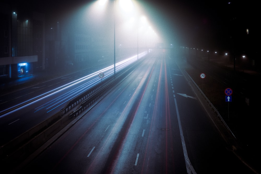 a foggy night with a street light in the middle of the road