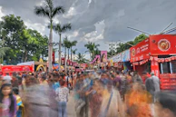 An aerial view of a bustling outdoor promotional event with vibrant banners and crowds.