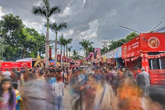 A bustling outdoor event with large, bold advertisements visible on banners and signage.