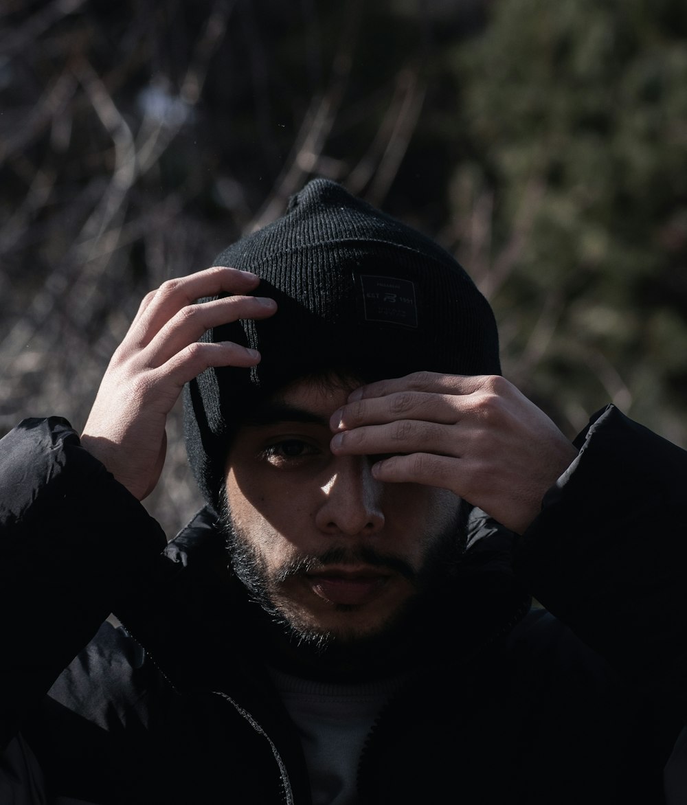 a man in a black jacket and a black hat