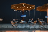 An inviting outdoor dining setup with lanterns and rustic furniture under a canopy of stars.
