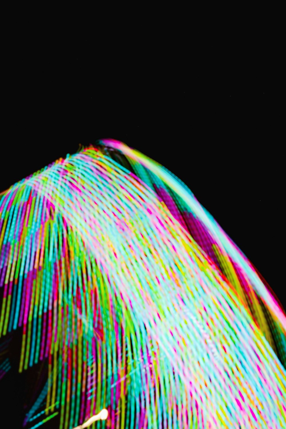 a blurry photo of a colorful umbrella in the dark