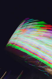 Dynamic shot of colorful sound waves pulsating over a dark background with neon gradients, capturing the energy of a lively party.
