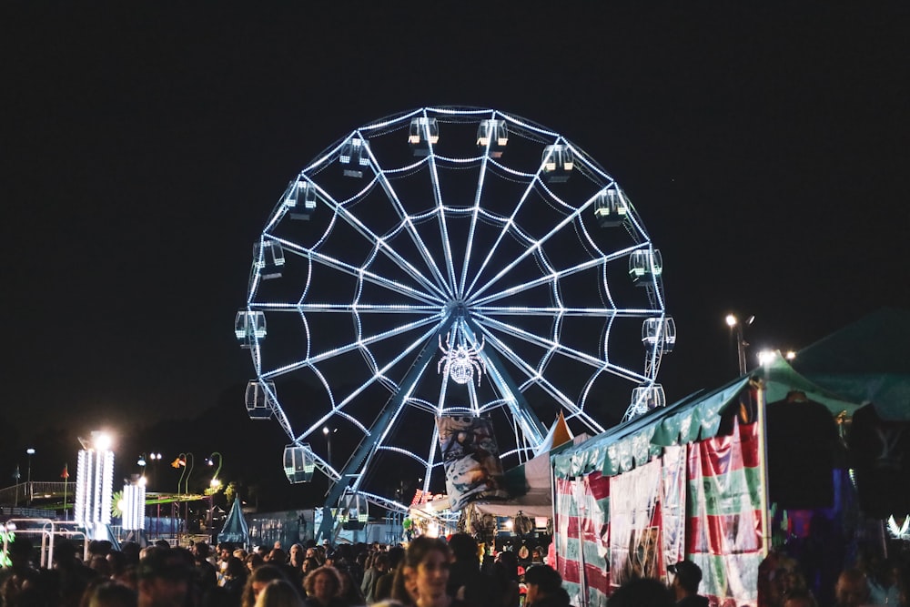 a large ferris wheel sitting above a crowd of people