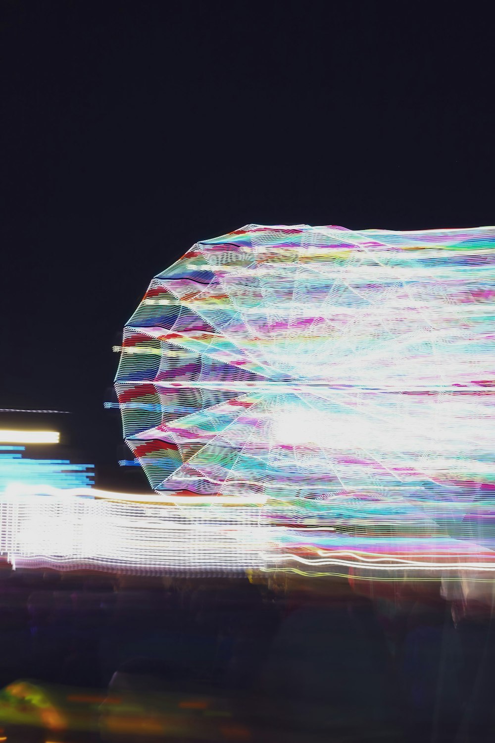 a blurry photo of a ferris wheel at night