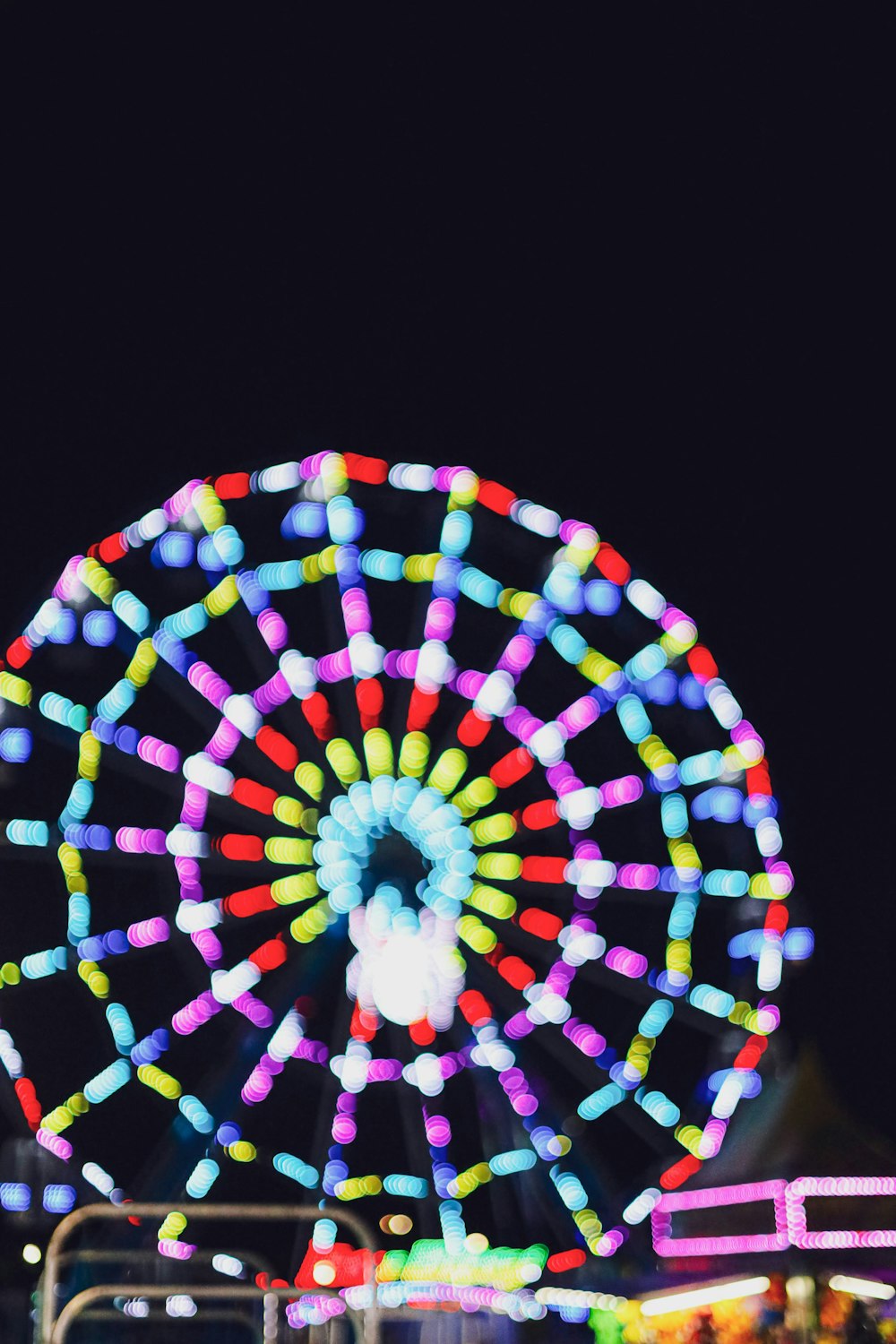 a colorful ferris wheel lit up at night