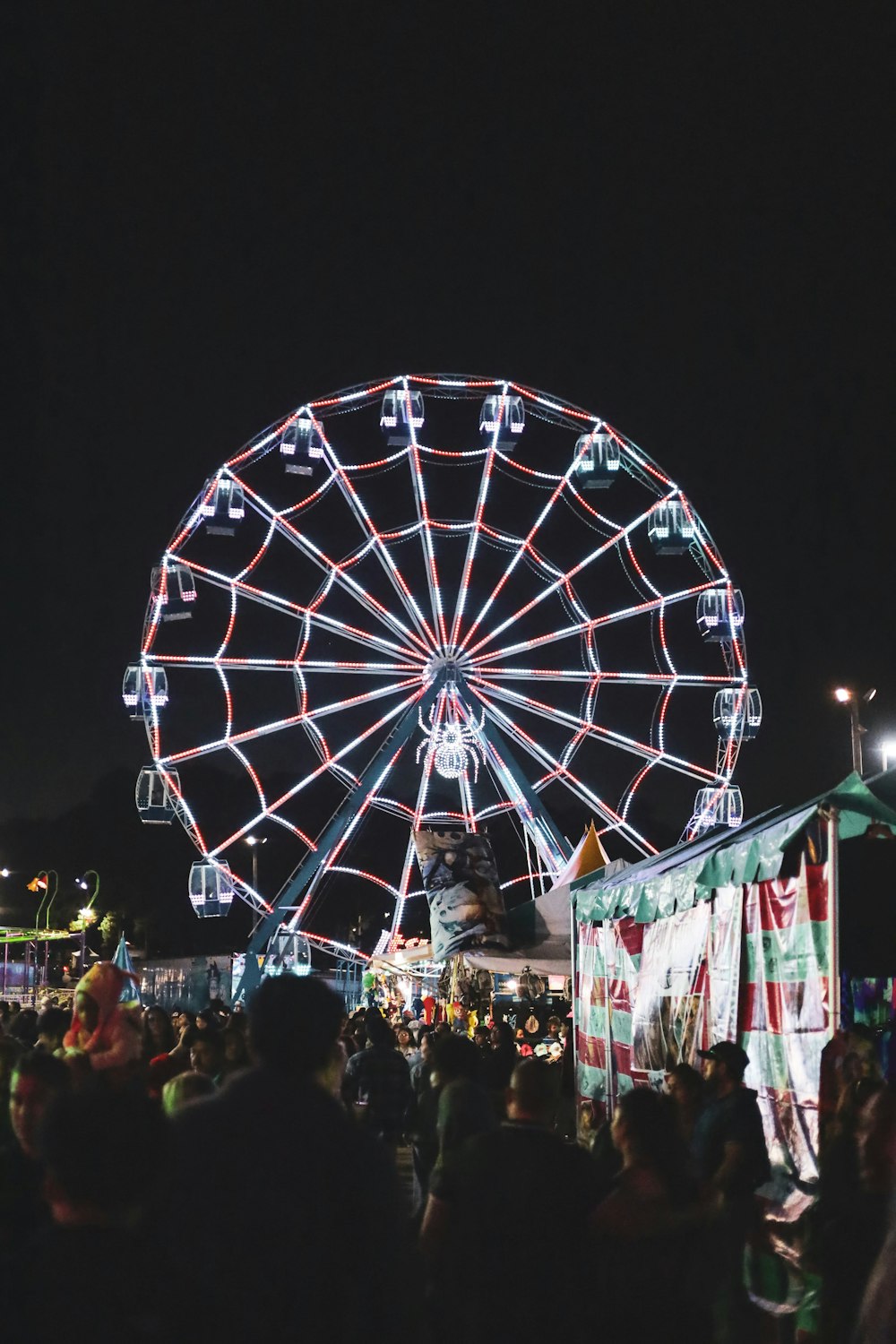 a large ferris wheel sitting above a crowd of people