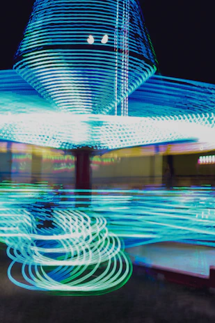Close-up of a spinning Beyblade with neon blue energy trails on a dark background