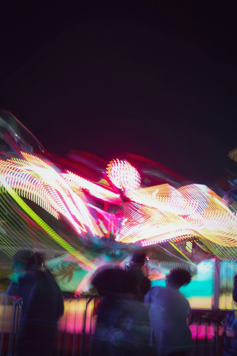 a blurry photo of a carnival ride at night