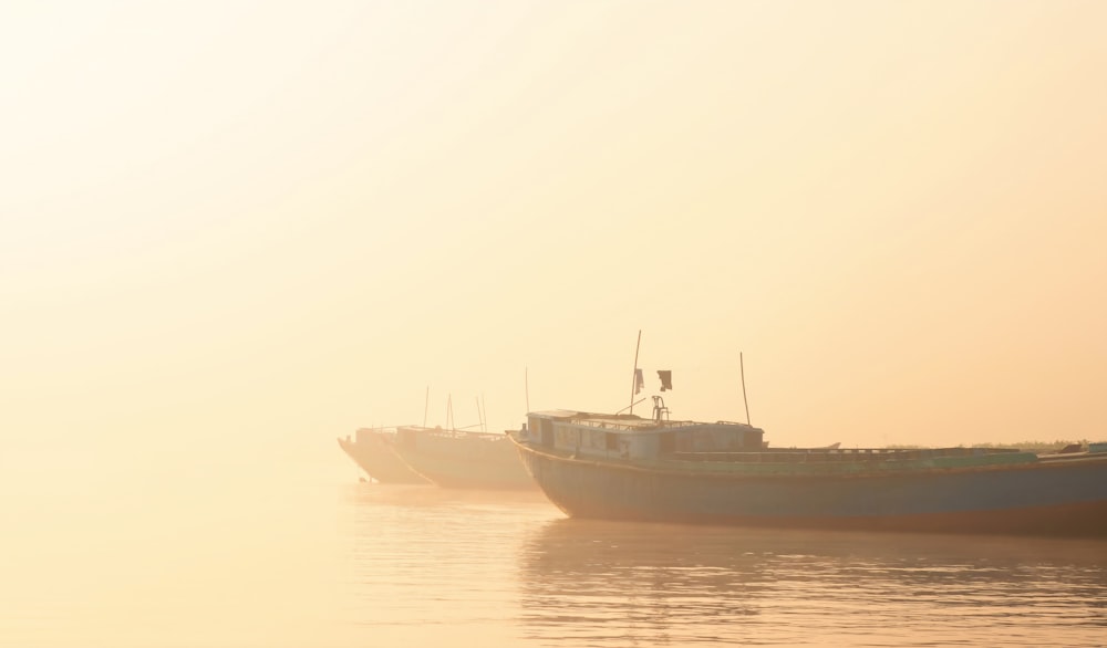 a couple of boats floating on top of a body of water