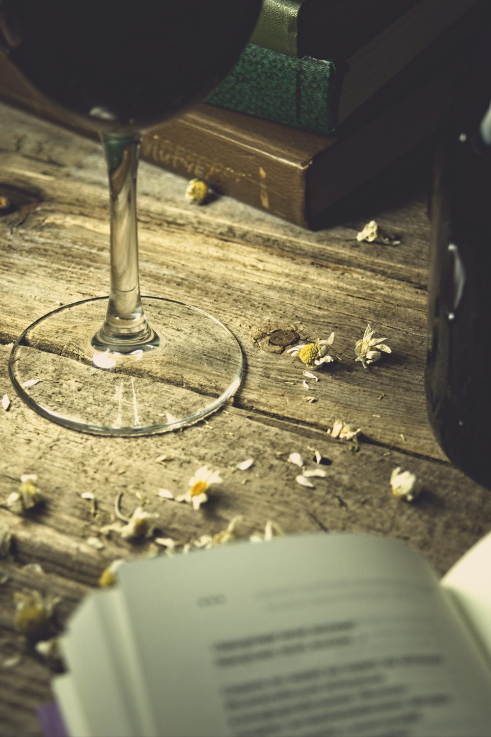 a glass of wine and a book on a table