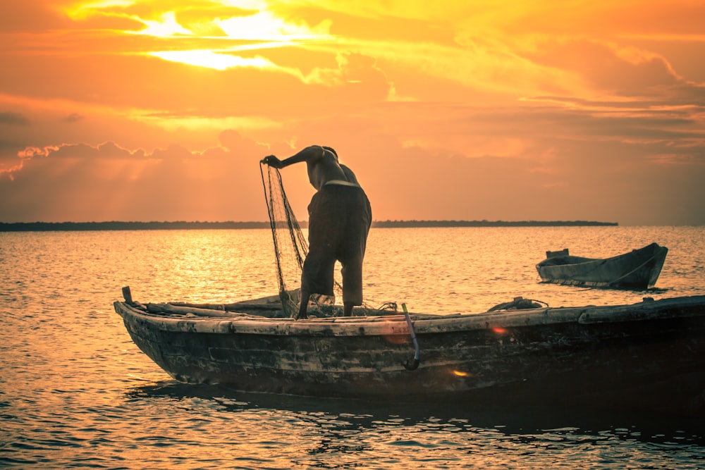 a man standing on top of a boat in the water