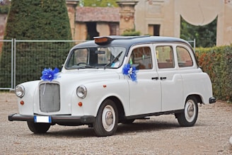 A charming vintage taxi waiting outside a cozy wedding venue at sunset.