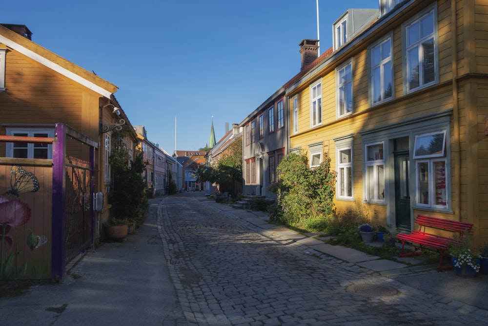 uma rua de paralelepípedos ladeada por casas amarelas