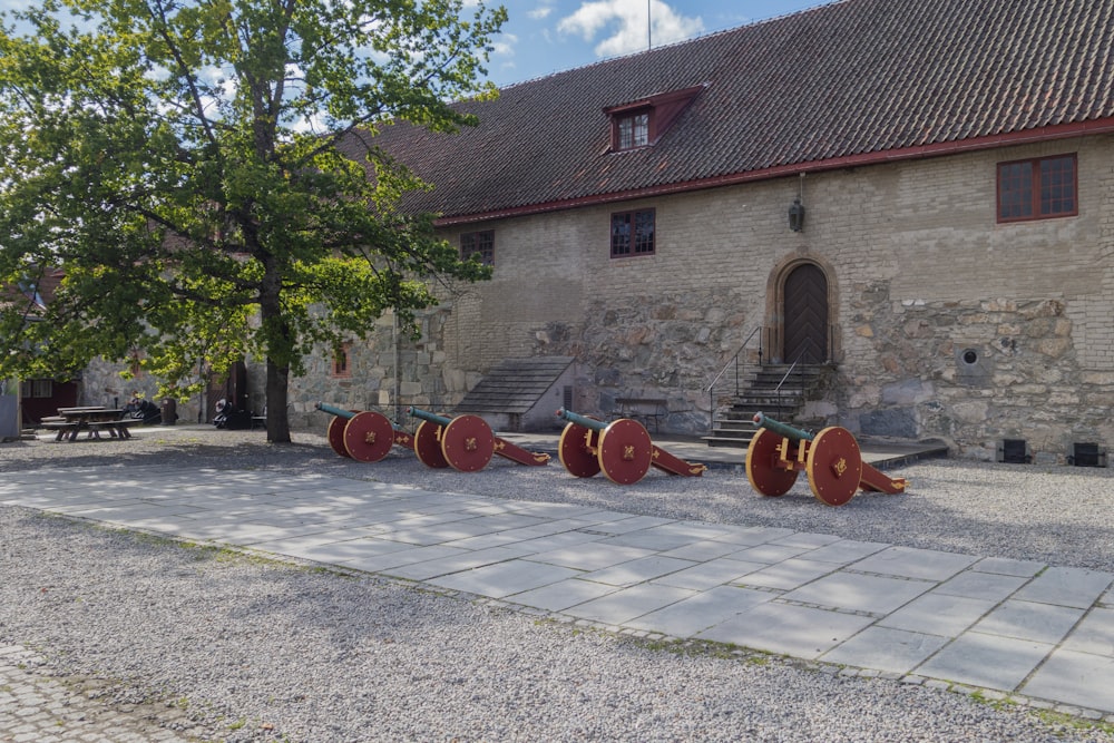 a row of red and gold musical instruments in front of a stone building