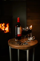 A cozy corner of the restaurant with warm lighting and a bottle of red wine beside a meat dish.