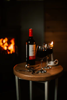 A cozy corner of the restaurant with warm lighting and a bottle of red wine beside a meat dish.
