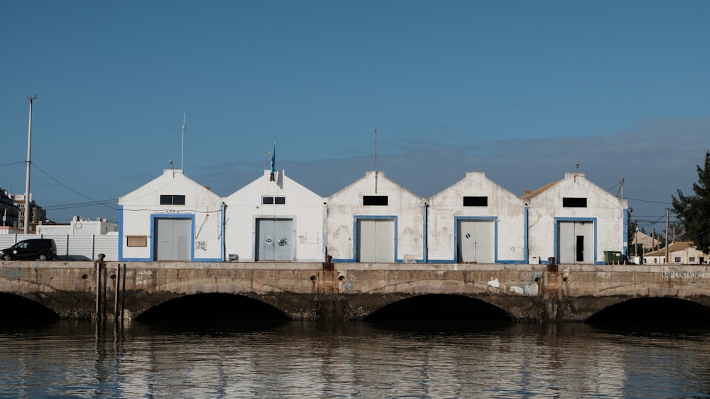 a row of white buildings sitting next to a body of water