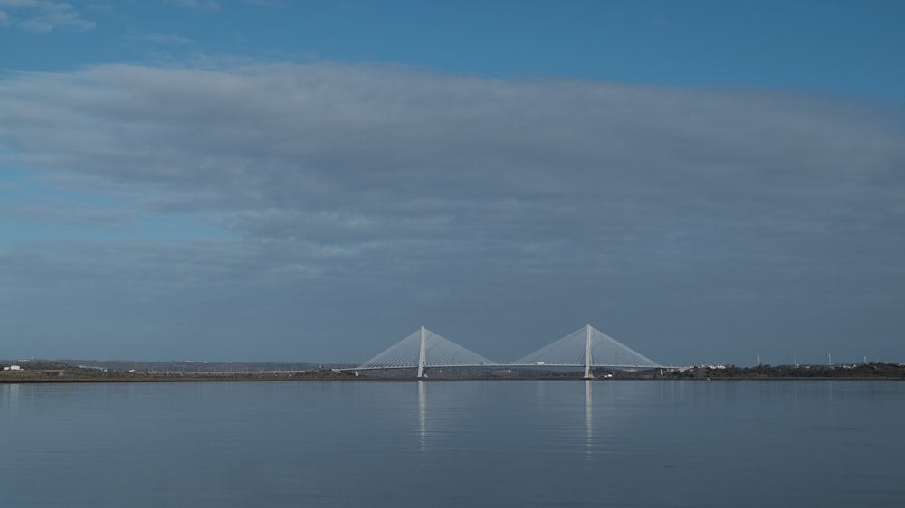 a large body of water with a bridge in the background