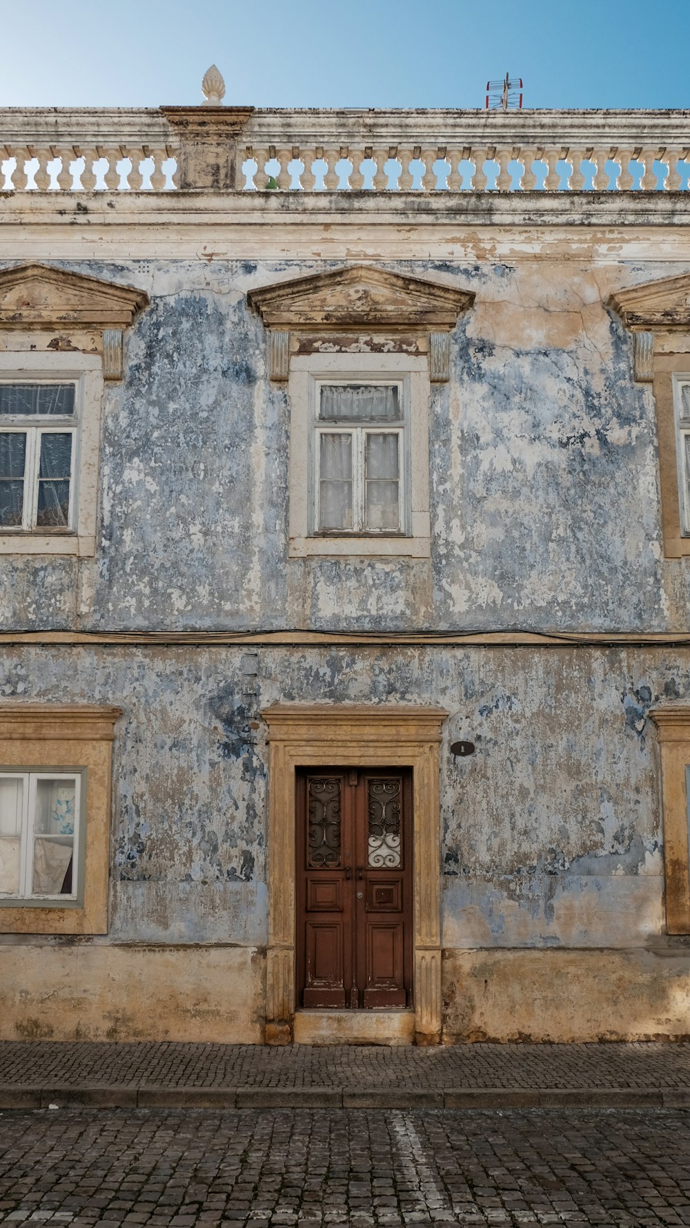 un vecchio edificio con una porta e finestre in legno