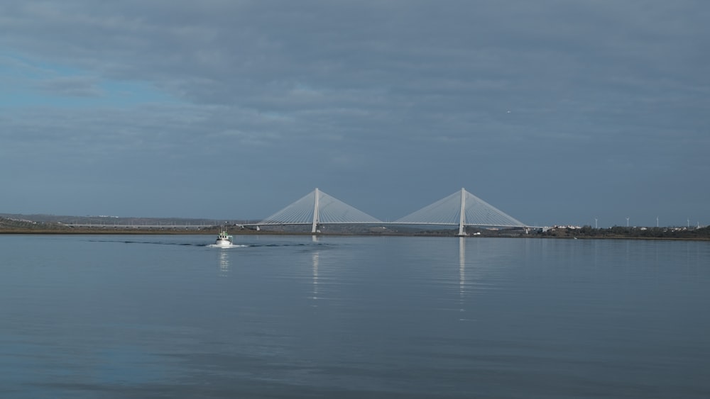 a large body of water with a bridge in the background