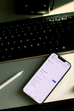 a cell phone sitting on top of a desk next to a keyboard