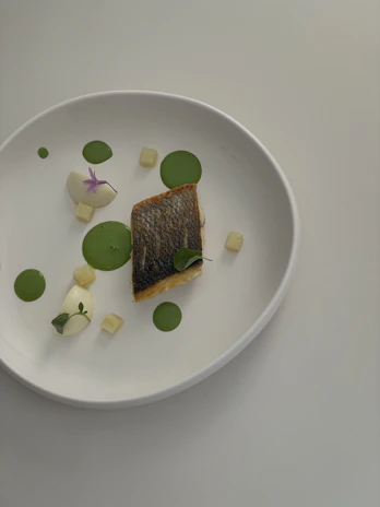 Artfully plated dish featuring seasonal ingredients in a minimalist Scandinavian setting.