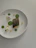 A close-up of a beautifully plated minimalist dish with fresh ingredients on a white ceramic plate.