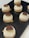 Several round pastries are arranged on a black serving tray. Each pastry has a light cream filling topped with a decorative brown chocolate piece. The surface of the pastries is smooth and creamy, with a slightly darker crust at the bottom.