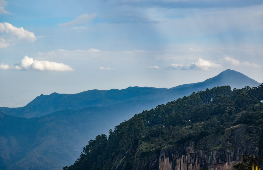 a view of a mountain range with trees and mountains in the background