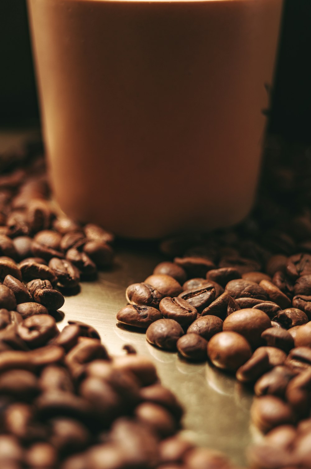 a cup of coffee sitting on top of a pile of coffee beans