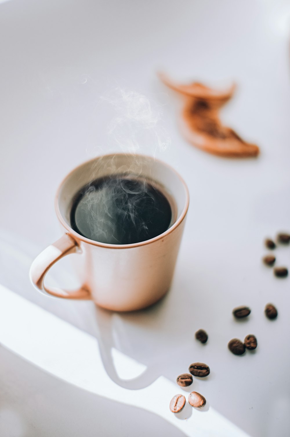 a cup of coffee with steam rising out of it