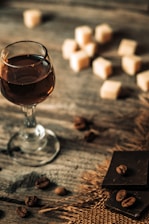 Close-up of organic chocolate bars and coffee cups on a rustic wooden table in a cozy cafe setting.