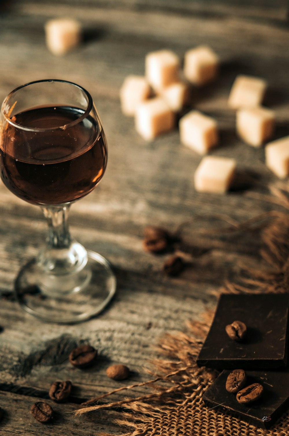 a glass of wine sitting on top of a wooden table