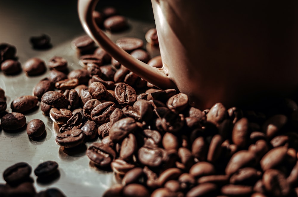 a coffee cup sitting on top of a pile of coffee beans