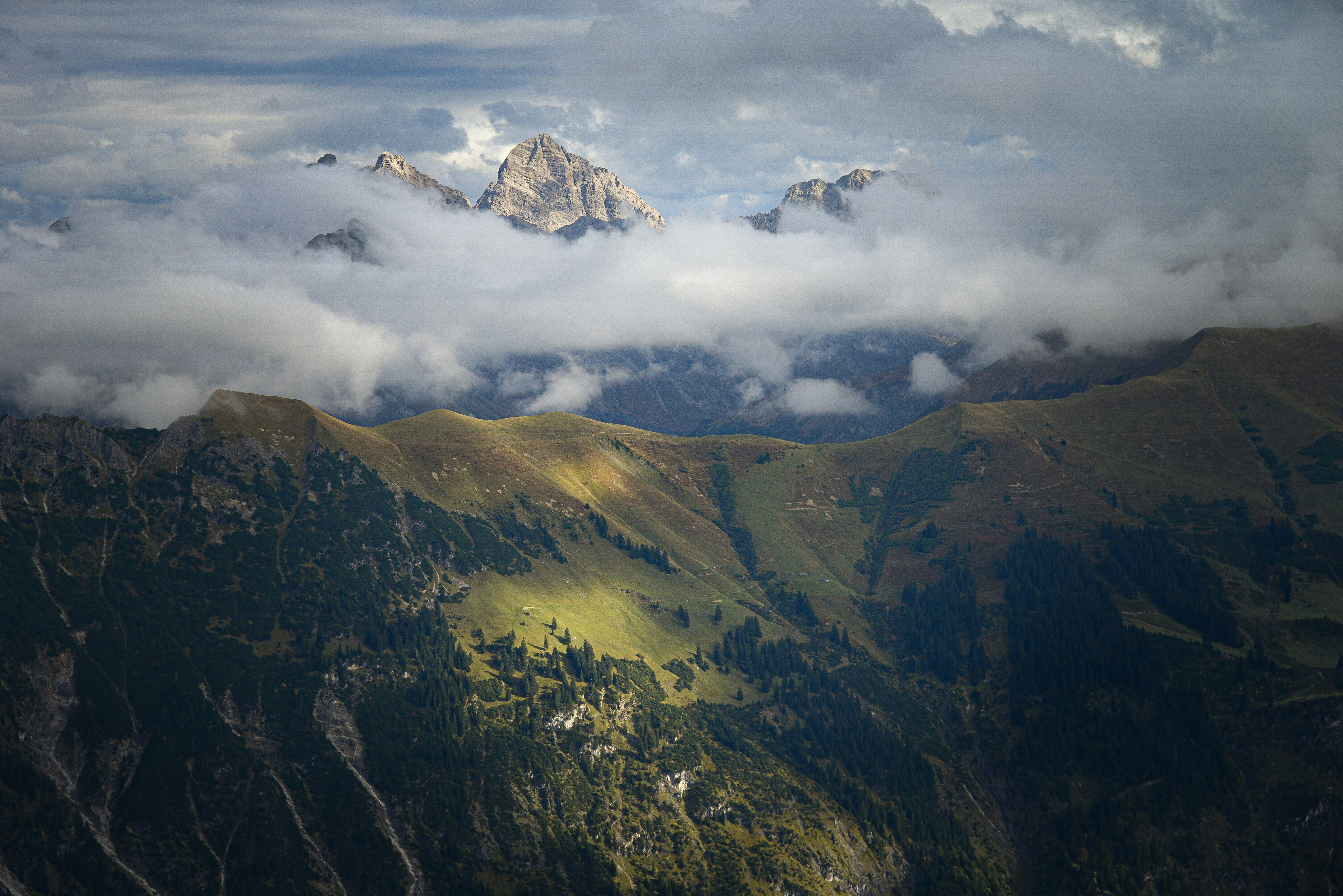a view of a mountain range covered in clouds