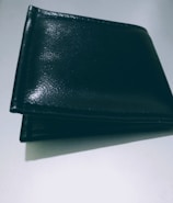 A close-up of a sleek leather wallet on a wooden table.