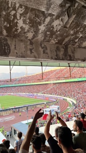 A packed stadium during an exciting football match with fans cheering.