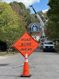 a road work ahead sign sitting on the side of a road