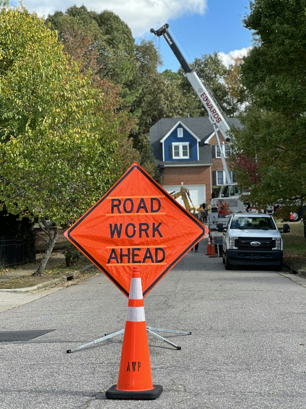 a road work ahead sign sitting on the side of a road