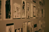 Storyboard sketches pinned on a dark wall with film grain texture overlay.