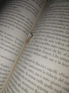 A beautiful engagement ring placed on a book of love poems.