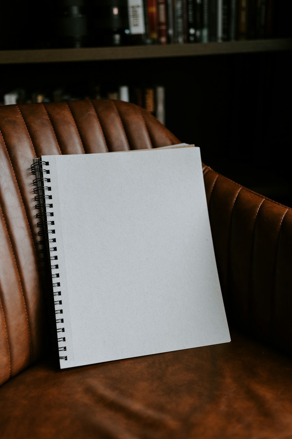 a notepad sitting on top of a brown leather chair